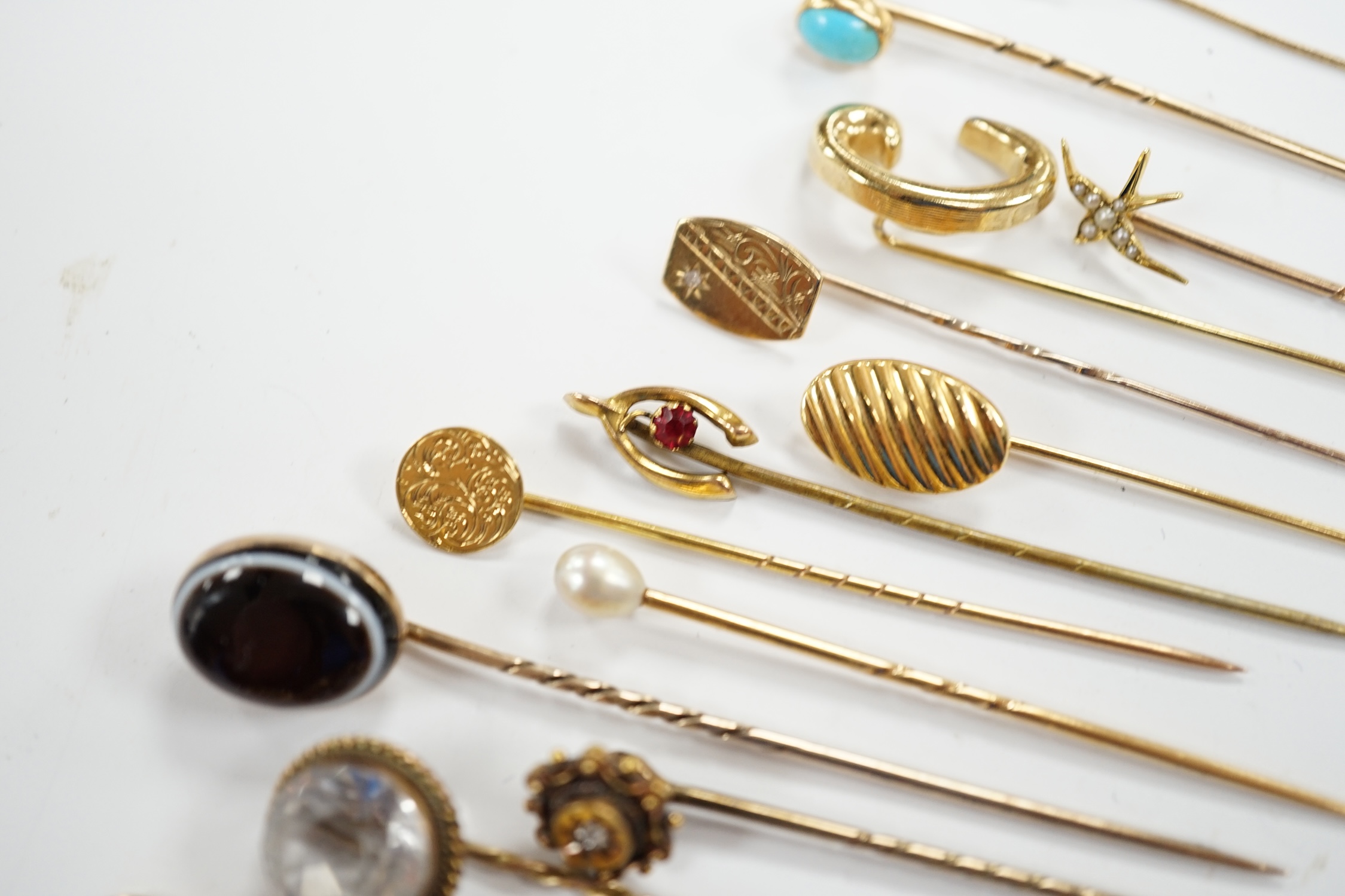 Fifteen assorted mainly early 20th century yellow metal and gem set stick pins, including diamond, seed pearl and banded agate, gross weight 23.1 grams.